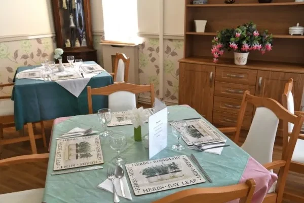 A dining table neatly laid with menus and glassware