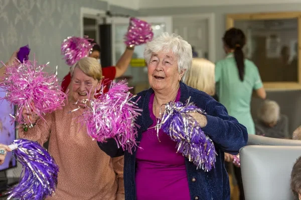 Residents waving pom-poms during a music and movement session