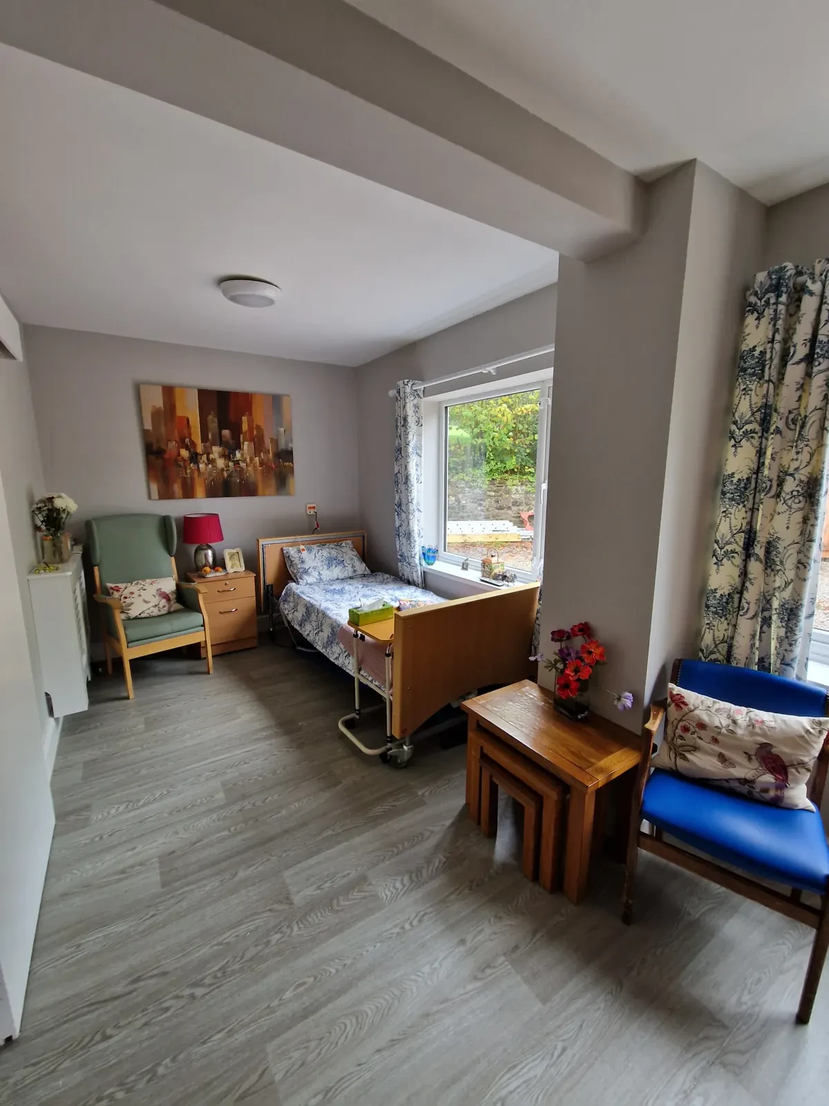 A bright, comfortable bedroom with an armchair and a window onto the garden