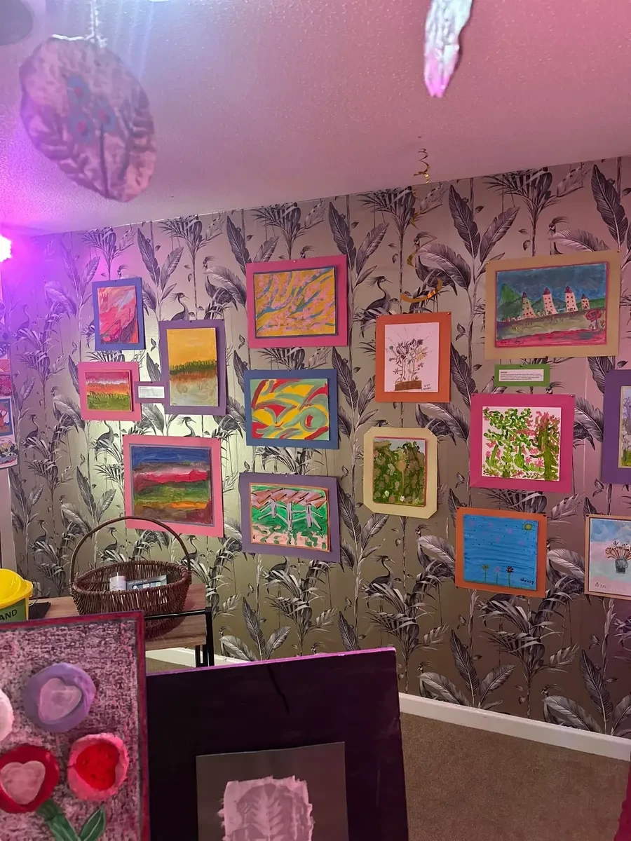 A wall of paintings and artwork made by residents at The Cedars and Larches