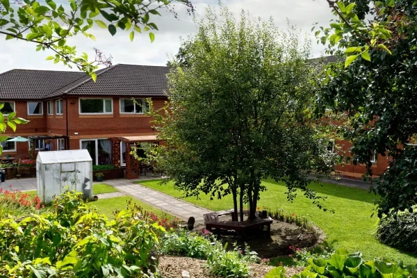 The front entrance of The Vale Care Home with flowers by the door