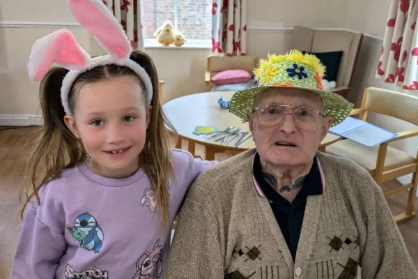 A resident and his granddaughter in matching Easter bonnets